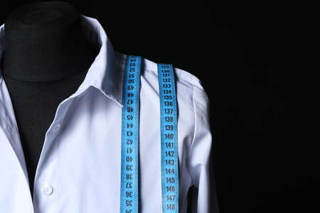 Mannequin with shirt and measuring tape on dark backgroundの写真素材