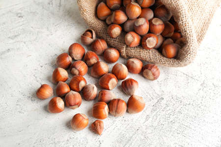 Bag with tasty hazelnuts on tableの写真素材