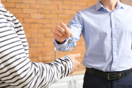 Real estate agent giving a key from new house to mature manの写真素材
