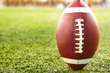 Rugby ball on green field outdoors