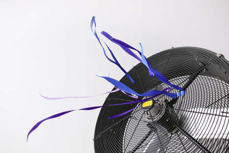 Electric fan with fluttering ribbons on light backgroundの写真素材