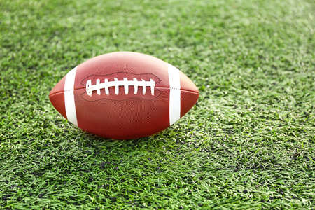 Rugby ball on green field outdoorsの写真素材