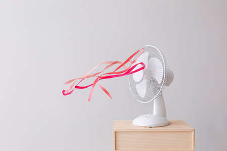 Electric fan with fluttering ribbons on light backgroundの写真素材