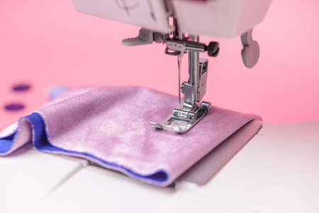 Sewing machine with cloth on color background, closeupの写真素材