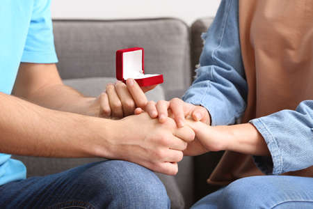 Young man proposing to his beloved at home