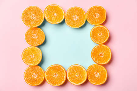 Frame made of ripe tasty tangerines on color backgroundの写真素材