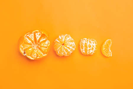 Ripe peeled tangerines on color backgroundの写真素材