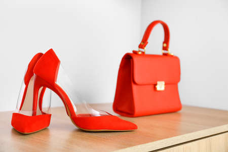 Stylish bag with high-heels on shelf in modern storeの写真素材