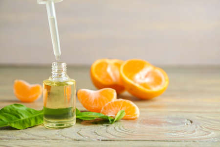 Bottle of tangerine essential oil on tableの写真素材