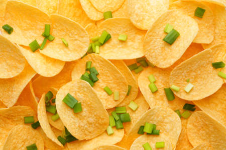 Tasty potato chips with green onion as backgroundの写真素材
