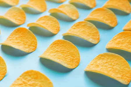 Tasty potato chips on color background