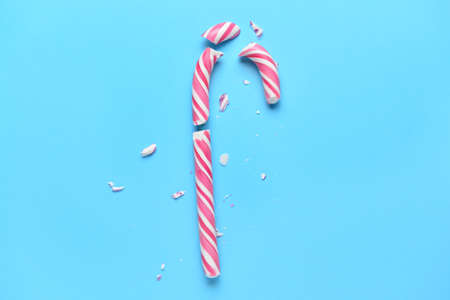 Broken candy cane on color backgroundの写真素材