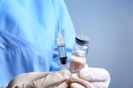 Cosmetologist with syringe and ampule with filler, closeup