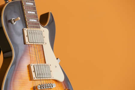 Modern guitar on color background