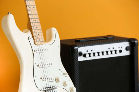 Modern guitar and amplifier on color backgroundの写真素材