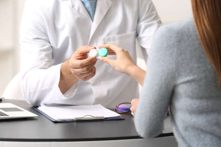 Ophthalmologist explaining patient how to use contact lensesの写真素材