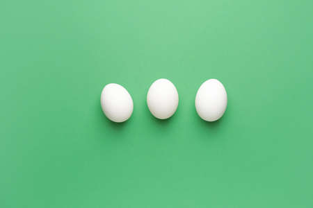 Fresh raw eggs on color backgroundの写真素材