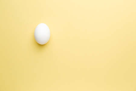 Fresh raw egg on color backgroundの写真素材