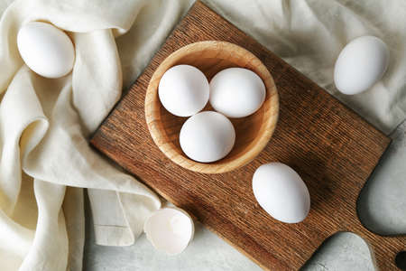 Bowl with fresh raw eggs on tableの写真素材