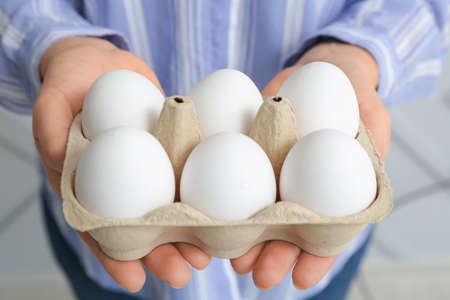 Woman with box of fresh raw eggs, closeupの写真素材