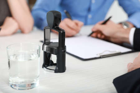Glass of water with stamp on table of notary public in office