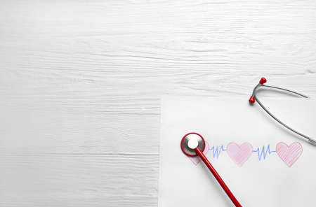 Stethoscope and drawing of pulse on wooden backgroundの写真素材