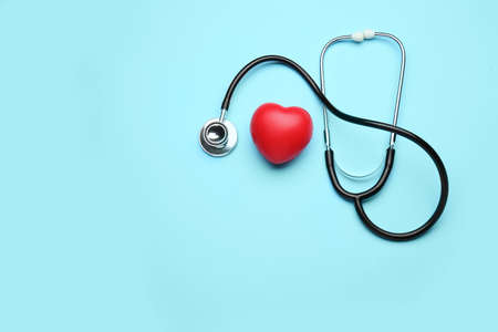 Stethoscope and heart on color backgroundの写真素材