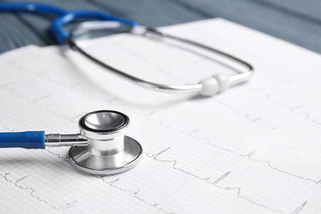 Stethoscope and cardiogram on table, closeup