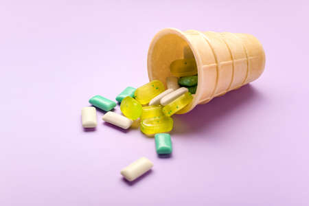 Wafer cone with different chewing gums on color backgroundの写真素材