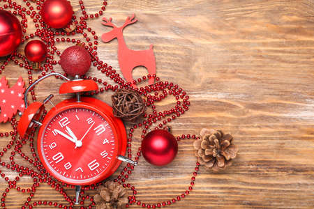 Alarm clock with Christmas decor on wooden backgroundの写真素材