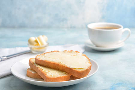Plate with slices of bread and butter on color backgroundの写真素材