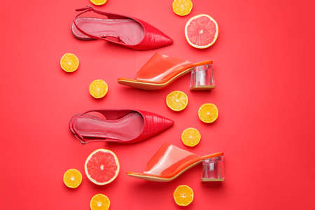 Stylish female shoes and citrus fruits on color backgroundの写真素材