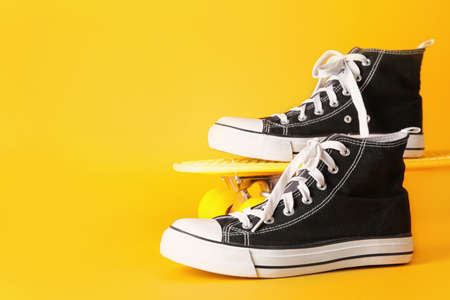 Stylish casual shoes and skateboard on color backgroundの写真素材