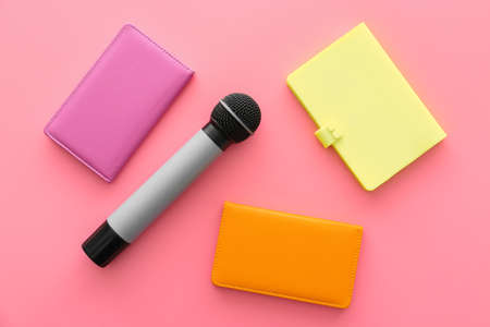 Journalist's microphone and notebooks on color backgroundの写真素材
