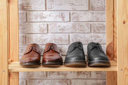 Shelf unit with stylish shoes near brick wallの写真素材