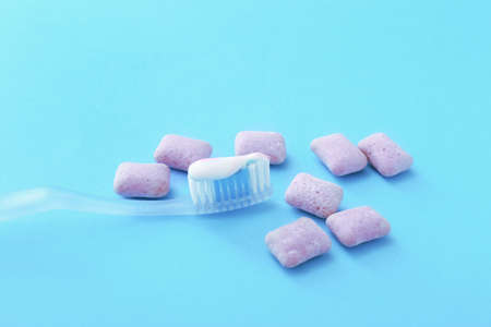 Tooth brush with paste and chewing gums on color backgroundの写真素材