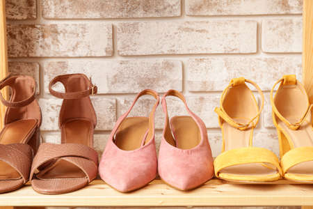 Shelf unit with stylish shoes near brick wallの写真素材