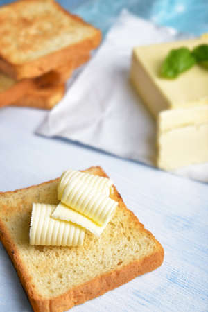 Slice of bread with butter on tableの写真素材