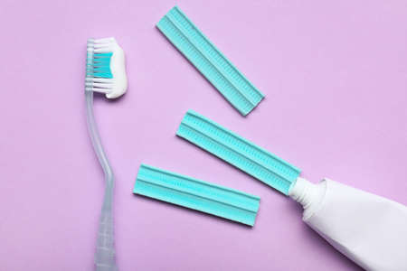 Tooth brush with paste and chewing gums on color background