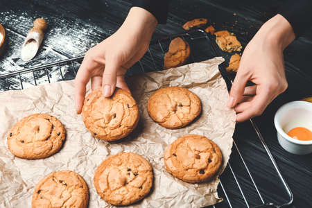 Woman with homemade cookies at wooden tableの写真素材