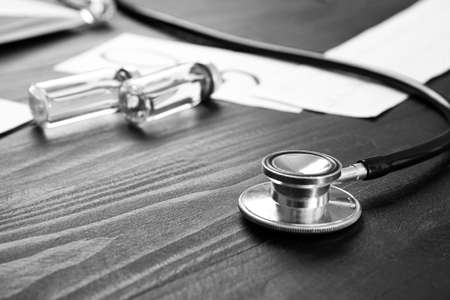 Stethoscope and medicines on wooden background