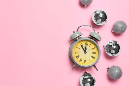 Alarm clock with Christmas balls on color backgroundの写真素材