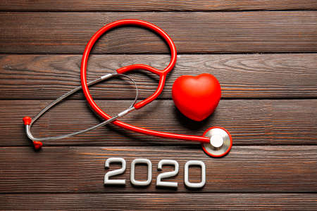 Stethoscope, heart and figure 2020 on wooden backgroundの写真素材