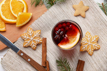 Glass of tasty mulled wine and cookies on tableの写真素材