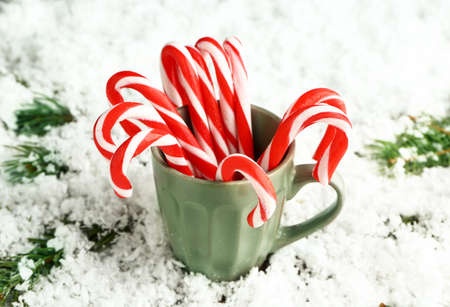 Mug with Christmas candy canes on snowの写真素材