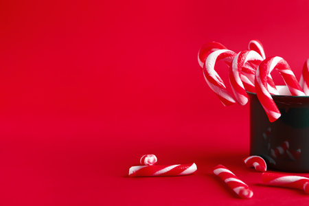 Mug with Christmas candy canes on color backgroundの写真素材