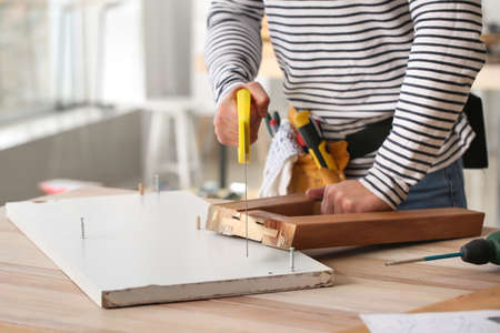 Handyman assembling furniture in workshopの写真素材