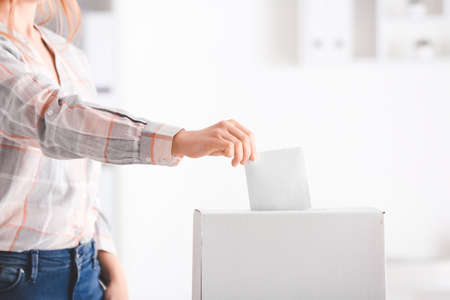 Voting woman near ballot box indoorsの写真素材