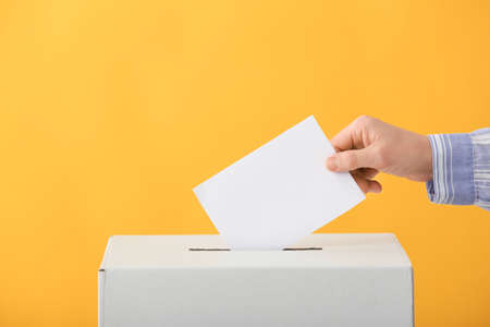 Voting woman near ballot box on color background