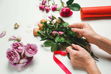 Female florist making beautiful bouquet on white backgroundの写真素材